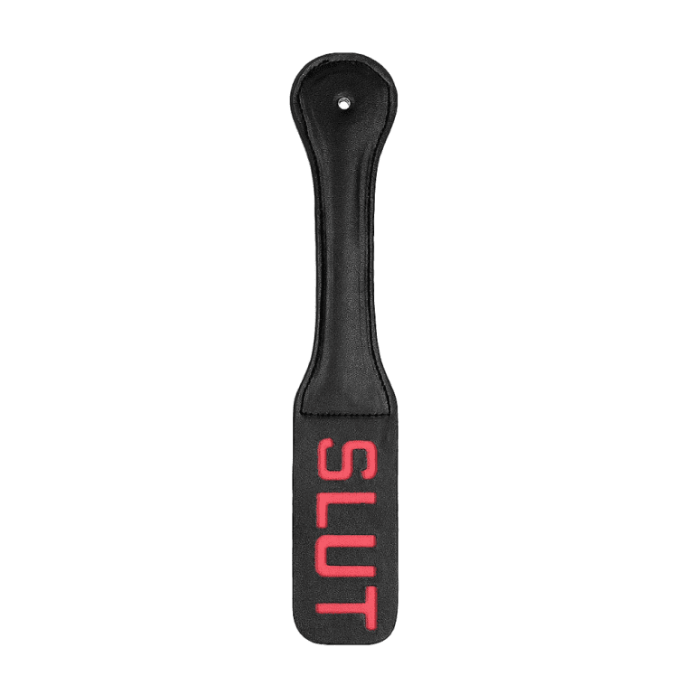 white background with black leather paddle with red cutout words spelling slut